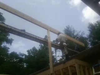 Carpenter setting a ridge beam over a new addition frame — Ice Dam Removal by Roofing Brothers in Dunbarton