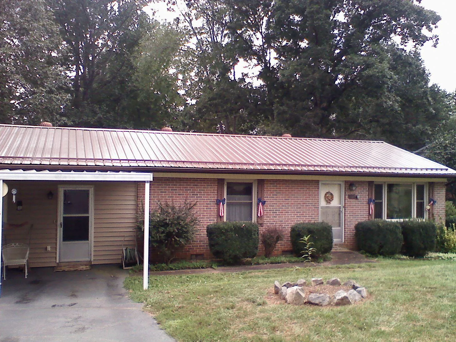 Bronze metal roof and carport on a brick ranch home — Roof Repair work by our crew in Dunbarton
